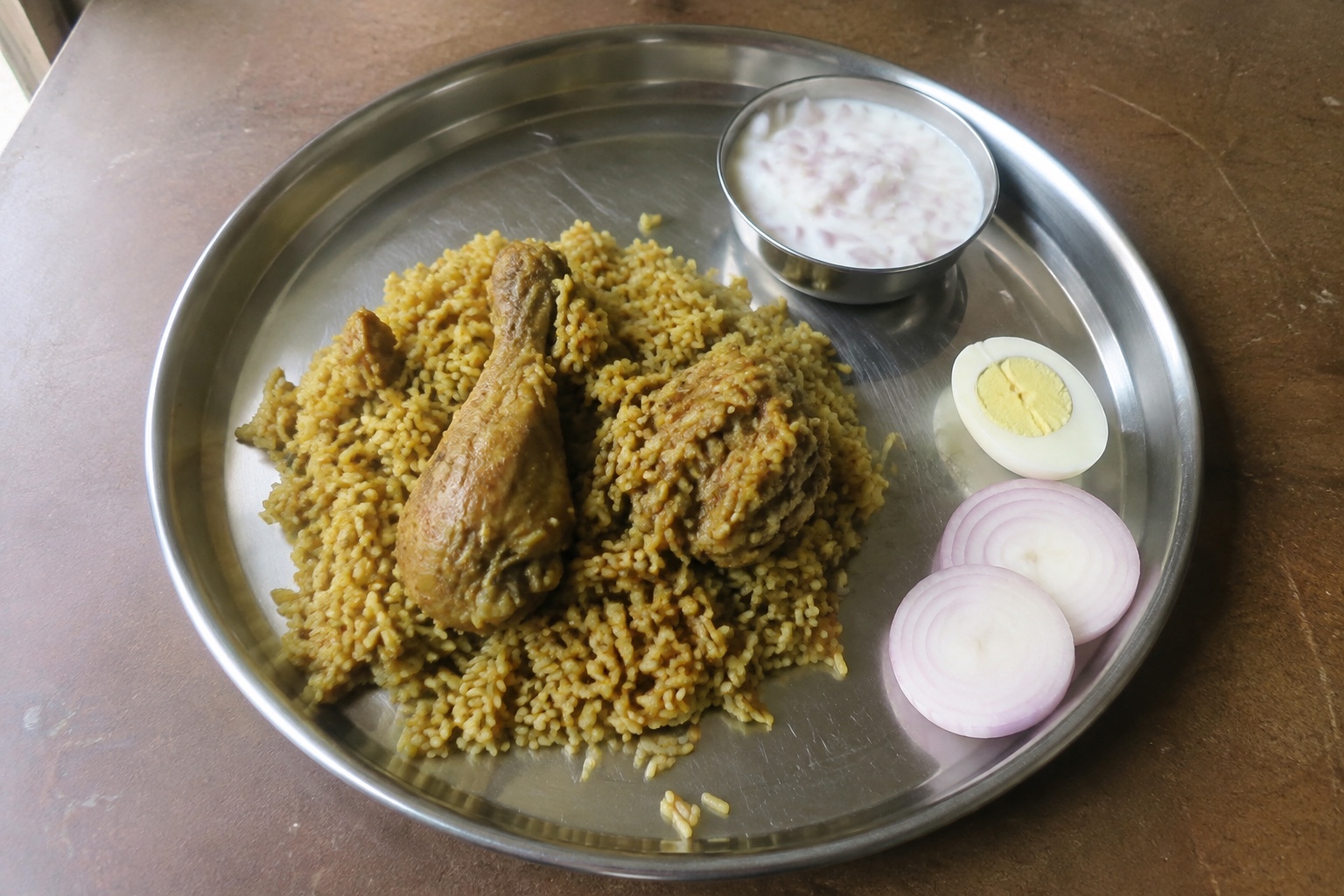 Chicken biryani, boiled egg and a small raita accompaniment